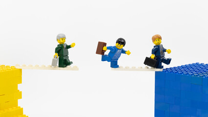 Naklejka premium Hong Kong - August 4 2025: a group of office boy take a challenge that walk on a tightrope