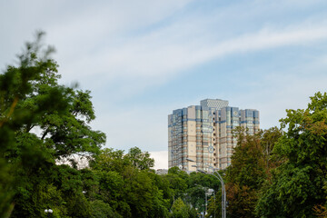 living multi apartment building ordinary object in city with green park zone horizon fluffy blue sky