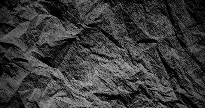 Dark Wrinkled Paper Texture Loop. Video featuring high-resolution rotating dark paper texture with folded triangular shapes and subtle seamless animation.