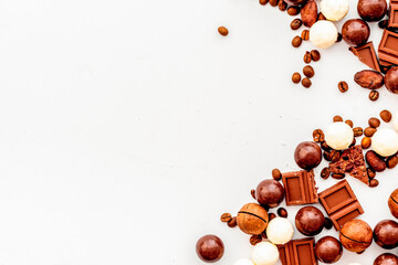 Chocolate background on white table top-down frame. Sweet desserts concept. Copy space