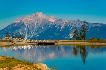 Alpine summer view with reflections and the Leoganger Steinberge mountains in the background at Lake Prinzensee, Mount Natrun, Maria Alm am Steinernen Meer, Salzburg, Austria