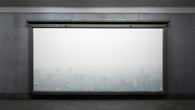 A wide window framing a hazy cityscape view with concrete walls - Powered by Adobe