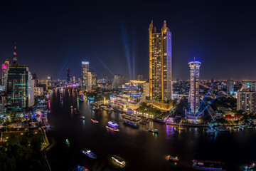 Modern buildings in the city with water reflection, firework, light show at night time.