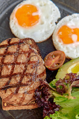 Deliciously Grilled Steak Garnished with Fresh Vegetables and Fried Eggs for a Wholesome Breakfast Experience
