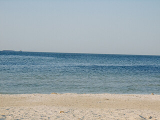 Scenic seashore with calm blue water and clear horizon, symbolizing travel, relaxation, and natural beauty.