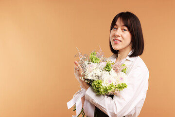 Florist with beautiful bouquet of flowers on beige background, space for text