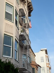 Beautiful American residential houses with outdoor exterior staircases, bay windows (bow windows) and Old Glory in residential district, California