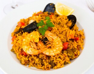 Seafood paella on a white plate, a traditional Spanish dish