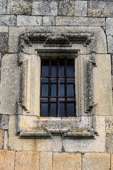 Naklejka premium Stone-framed window with iron bars on San Miguel Church in Villavega de Ojeda