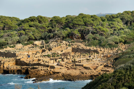 Wide angle panorama of the ruins of the Roman Archeological Park of Tipaza, Tipasa, Algeria. Tourists on the site.