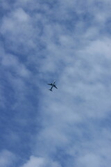 Aircraft flying in formation through a blue sky with clouds