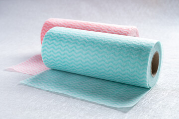 blue and pink rolls of nonwoven cleaning cloth