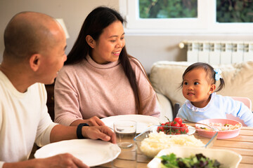 Asian family enjoying healthy meal together at home