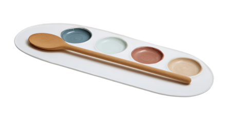 A white oval platter holds five small, colored wells, likely for dipping or mixing. A wooden spoon rests alongside