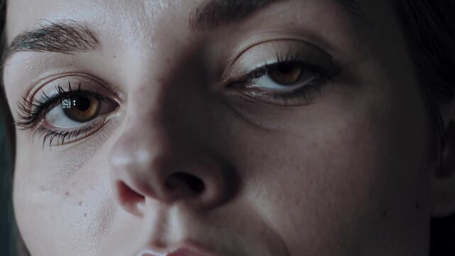 Haunting close up revealing woman's terrified expression, fragmented glass reflecting overwhelming fear and vulnerability in her wide, traumatized eyes