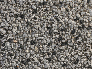 A detailed view of small gray and black pebbles creating an interesting surface texture.