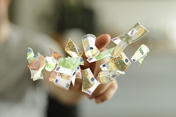 Image of a hand with floating euro banknotes. Ideal for finance, wealth, and money concepts.