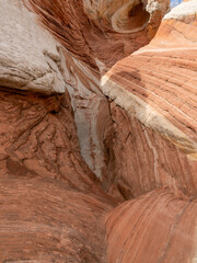 White Pocket in Utah, USA, a remote ecpanse of Navajo sandstone sculpted by wind and erosion into swirling, brain-like formation with vivd red, pink, orange, and white layers