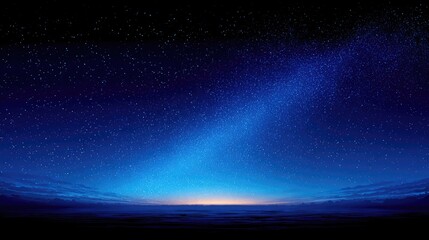 Starry night sky over a dark horizon. Vast expanse of a deep blue night sky dotted with numerous stars. A band of pale light, resembling dawn or dusk, touches the horizon