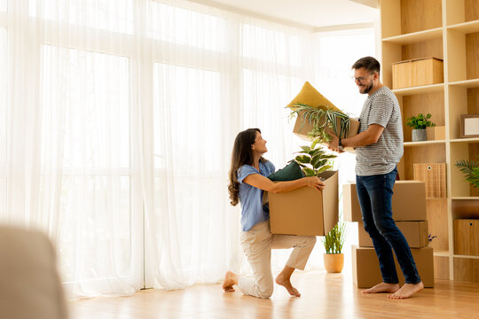 Couple joyfully moving into their new home with plants and boxes