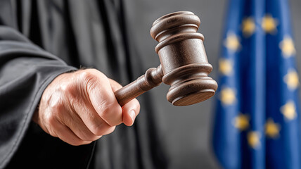 Symbol of justice in action, judge with wooden gavel against the background of the European Union flag. Ideal for topics on law, the judicial system and international jurisdiction.