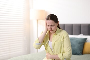 Young woman suffering from headache at home, space for text