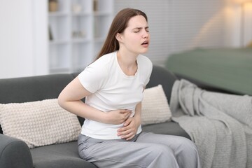 Young woman suffering from stomachache at home