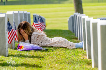 Kneeling in Sorrow: A Bride's Silent Tribute at a Military Cemetery