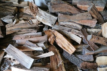 A stack of firewood with varied textures and tones