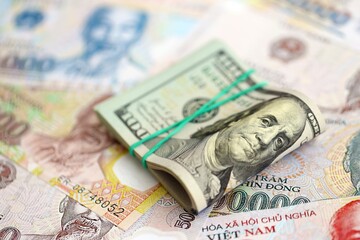 Vietnamese dong currency money bills and bunch of us dollar banknotes. The concept of economics and currency exchange