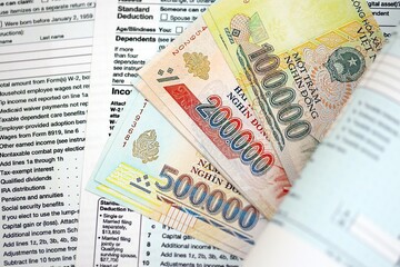 Vietnamese dong money bills on tax form. Taxation and accounting concept