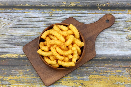 Puffed corn peanuts snacks isolated on wooden background.