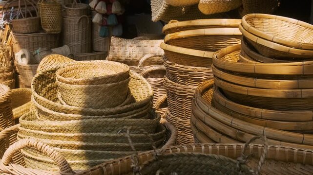 Collection of handmade wicker baskets, trays, hats and weaving bags displayed at traditional market in Chiang Mai, Thailand. Store with handmade goods, traditional craftsmanship, sustainability
