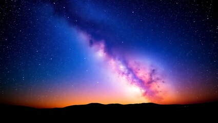 Fototapeta premium A breathtaking view of the milky way galaxy over a dark silhouette of distant mountains at night