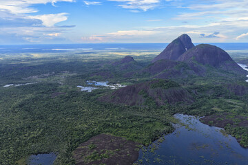 Aerial view of the majestic Cerros de Mavecure rising dramatically from the lush green Amazonian rainforest, a symphony of natural beauty, Inirida, Guainia, Colombia.