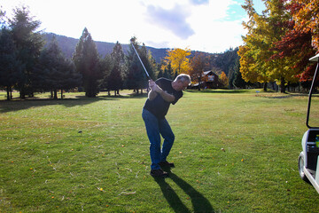 Senior man playing golf on a small rural golf course called Kayler's Bend on the Clearwater River near Lenore  ID