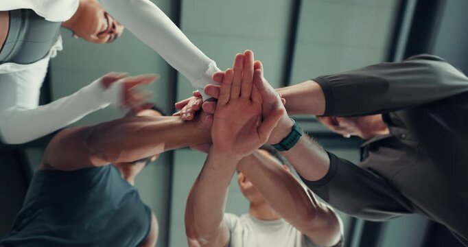 People, fitness and team with hands together below for unity, collaboration or mission in gym. Low angle, group or community with pile or stack for huddle, solidarity or cohesion in health club