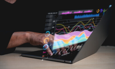 A person interacts with a futuristic laptop displaying vibrant data visualizations, showcasing graphs and statistics in a high-tech environment.