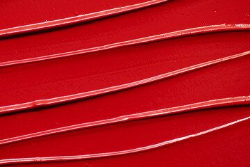 Red lipstick background. Beauty cosmetic texture. Makeup products. Smudged red lipstick texture.