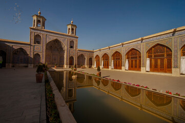 View of beautiful of Nasir Al-Mulk Mosque reflected in pond  in courtyard. It is located in Shiraz, Iran. 