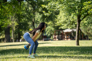 Beautiful smiling woman training with kettlebell swing in morning park, full body fitness workout,...