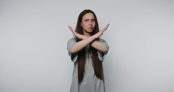 concerned woman crosses her arms in refusal gesture on white background