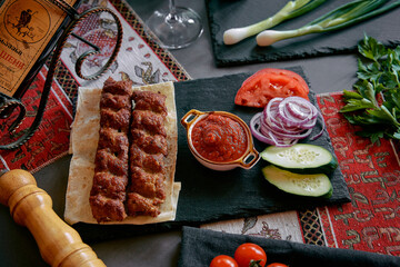 Deliciously Grilled Skewers with Fresh Vegetables and Flavorful Sauce Served on a Rustic Slate Board for a Tempting Culinary Experience