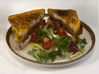Roasted beef sandwich with mustard, cream cheese and a salad on  a plate