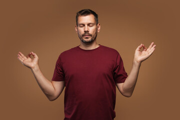 Panic attack. Man meditating to calm down on brown background © New Africa