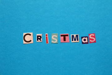 Christmas spelled with colorful cutout letters on blue background