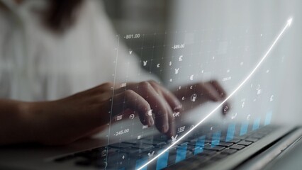 A close-up view of hands typing on a laptop, featuring a digital financial graph and currency symbols overlay, symbolizing growth and contemporary investment strategies. Copula
