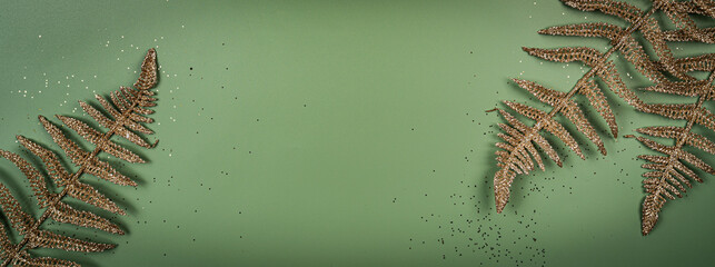 Tropical summer green background with golden fern leaves set in the frame around blank space for a text, flat lay, top view. Web banner