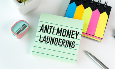 A green piece of paper with the word Anti Money Laundering written on it