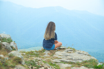 Naklejka premium Young girl enjoying time in the edge of a cliff.